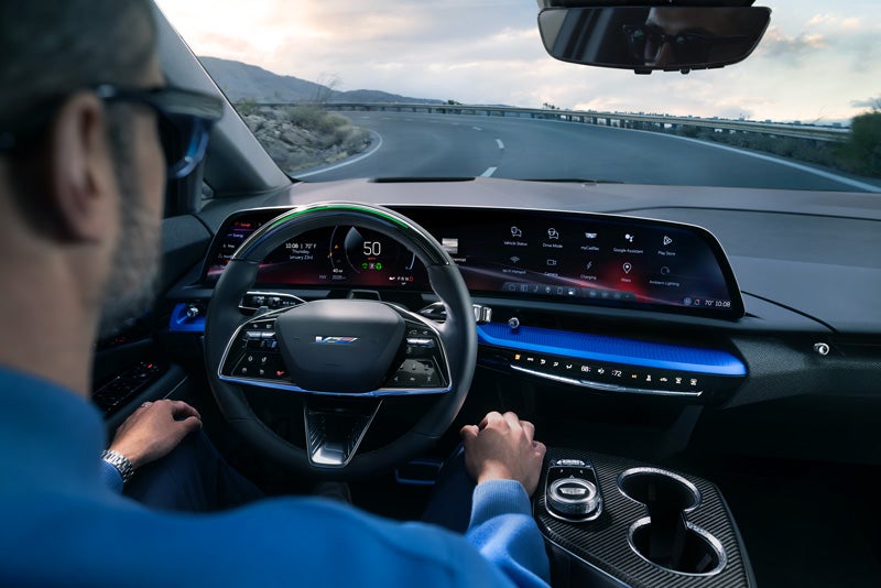 Front View of the 2026 OPTIQ-V Driving Through the Dusk Utilizing its Headlights | Bergstrom Cadillac of Madison in Madison WI